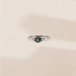 Bague création saphir teal central épaulé de deux diamants, or blanc